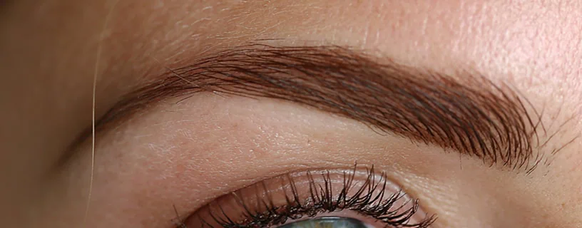 Dieses Bild zeigt perfekt geformte und mit der Pudertechnik schattierte Augenbrauen einer zufriedenen Kundin.